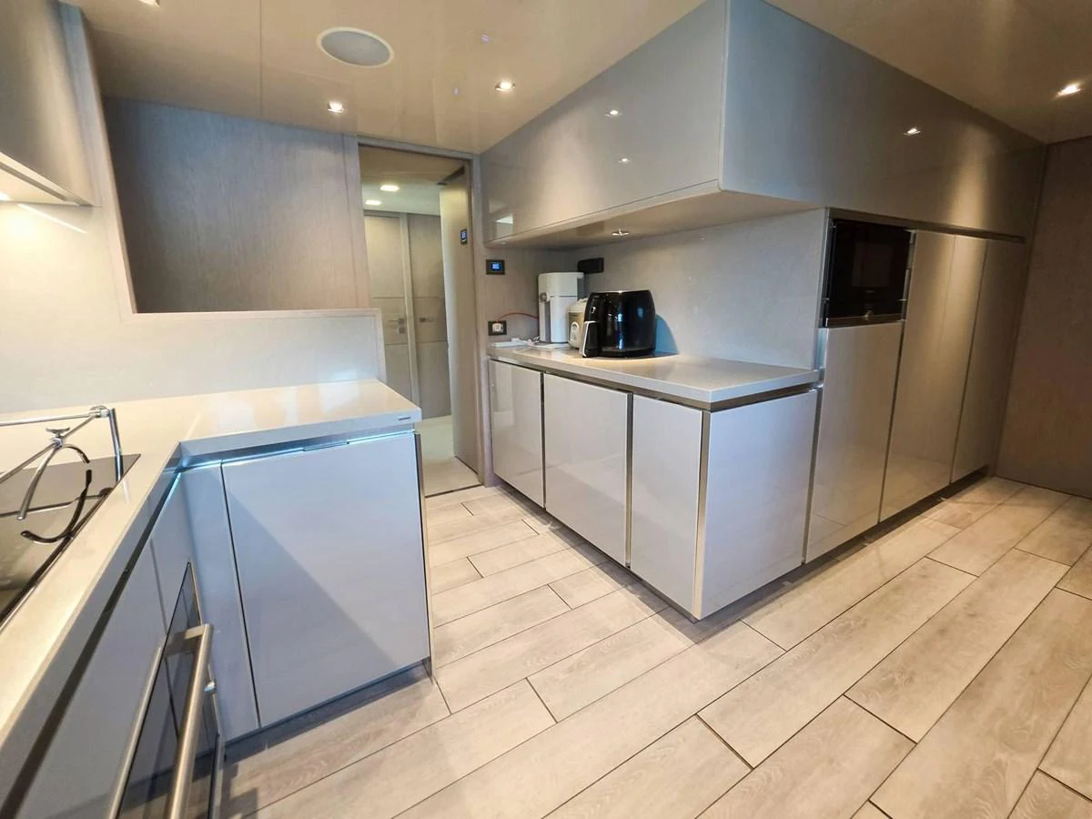 a kitchen with white cabinets aboard CUSTOM LINE 108 Yacht for Sale