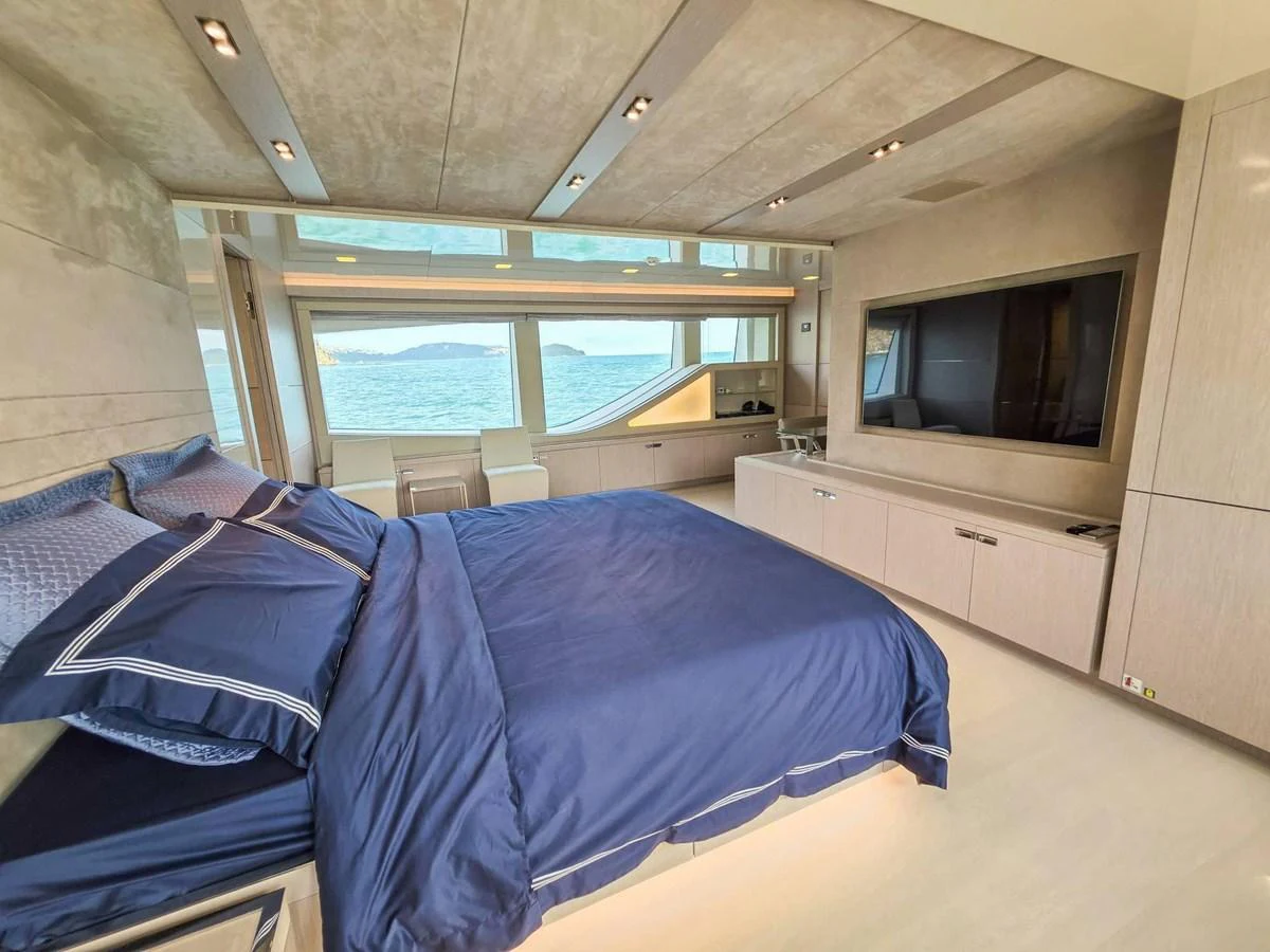 a room with a bed and a tv aboard CUSTOM LINE 108 Yacht for Sale
