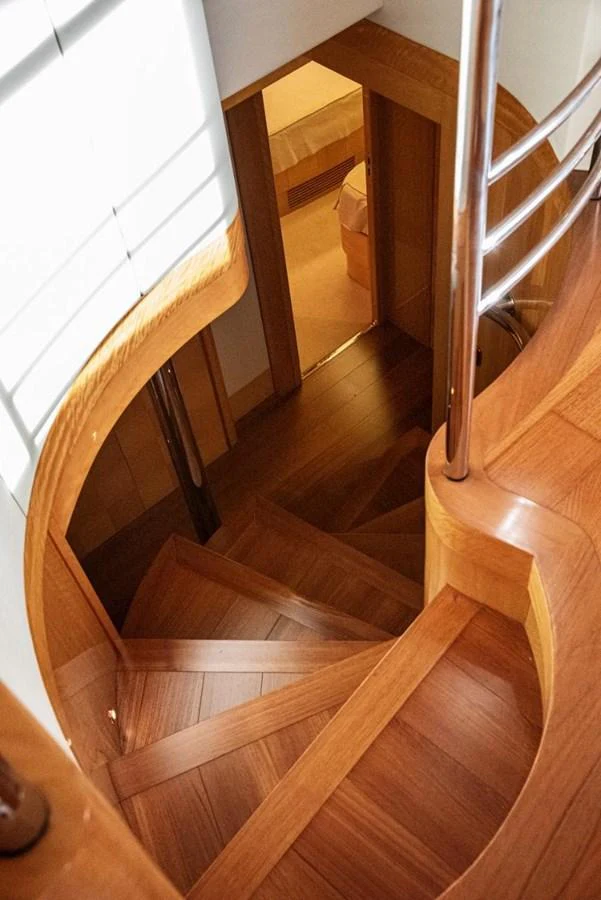 A beautifully crafted wooden staircase leads to the lower deck, showcasing elegant design and craftsmanship. aboard AZIMUT 105 Yacht for Sale