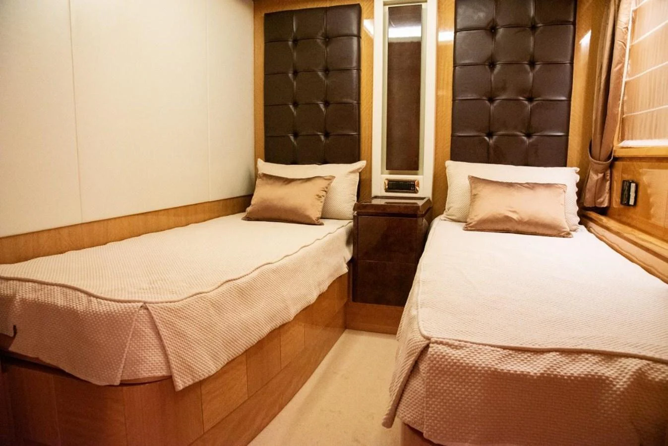 The guest stateroom features twin beds with elegant bedding and a warm, inviting atmosphere. aboard AZIMUT 105 Yacht for Sale