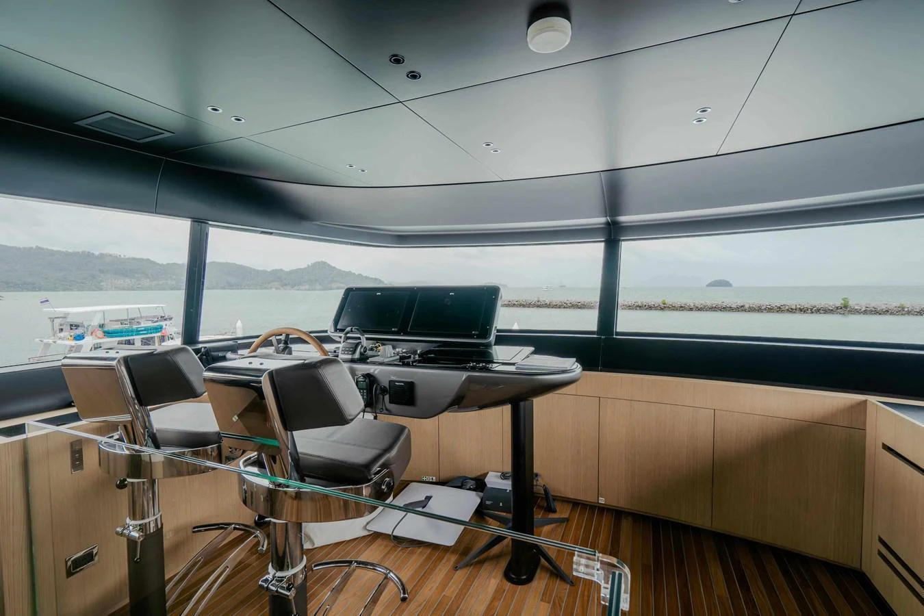 The helm station offers a panoramic view with modern navigation equipment and comfortable seating. aboard SANLORENZO SX100 Yacht for Sale