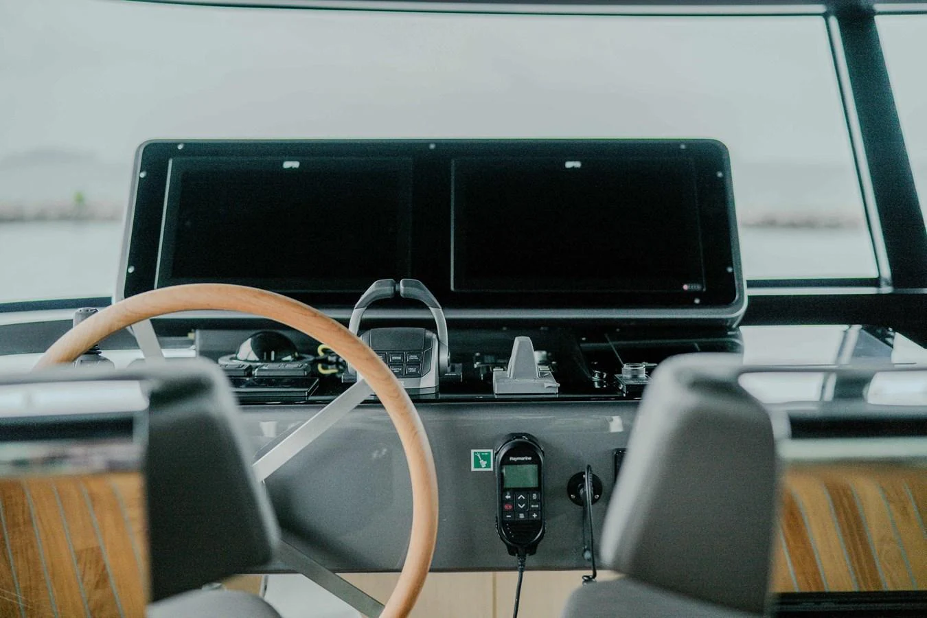 The helm station features modern navigation equipment and a sleek wooden steering wheel. aboard SANLORENZO SX100 Yacht for Sale