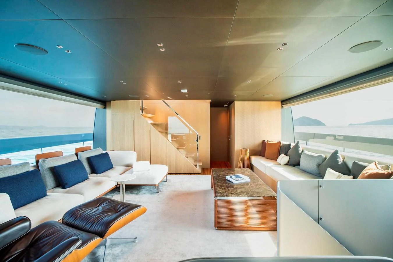 The salon features modern furnishings with panoramic windows offering stunning sea views. aboard SANLORENZO SX100 Yacht for Sale