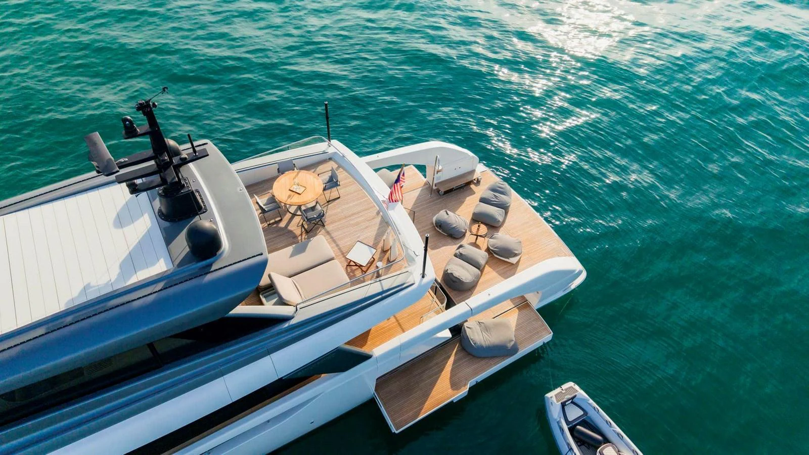 The yacht features a luxurious aft deck with sun loungers and a dining area, perfect for relaxation and entertainment. aboard SANLORENZO SX100 Yacht for Sale