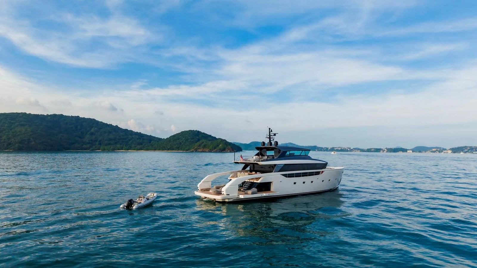 A sleek, modern yacht cruising in a serene coastal setting with a tender nearby. aboard SANLORENZO SX100 Yacht for Sale