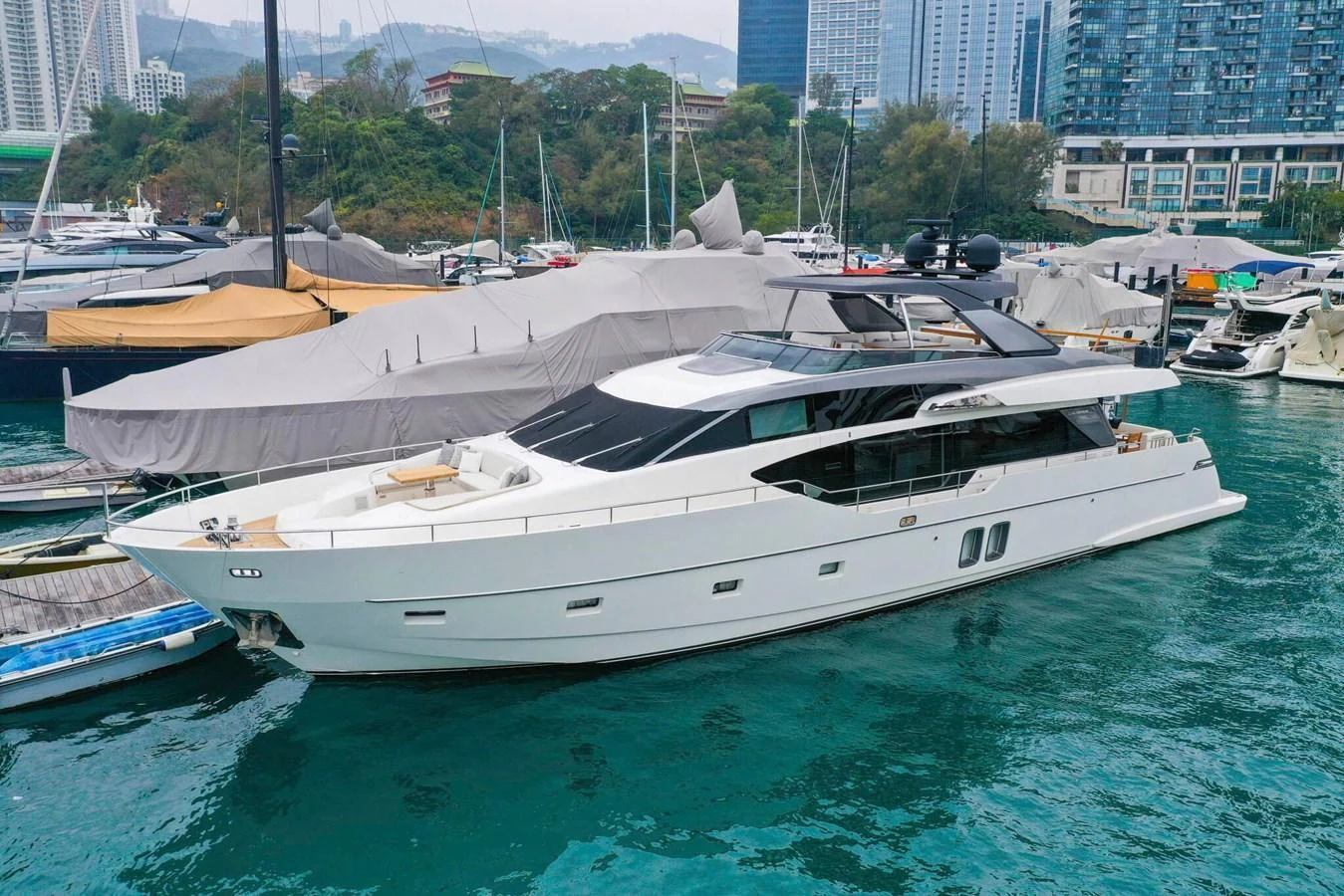 A sleek and modern yacht is docked in a marina, showcasing its elegant design and spacious deck areas. aboard SANLORENZO SL86 Yacht for Sale