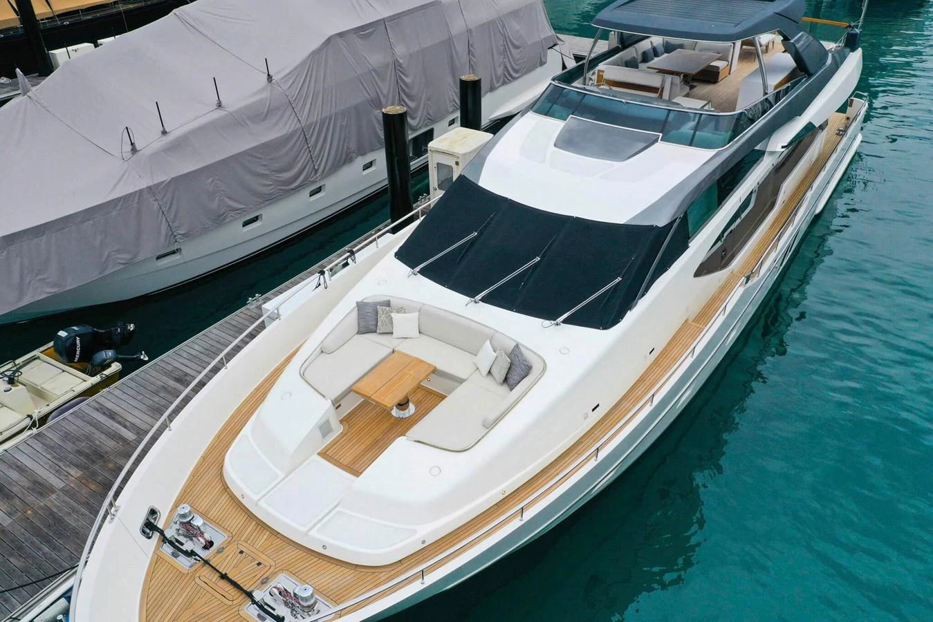 A sleek and modern yacht docked in a marina, showcasing its spacious deck and luxurious design. aboard SANLORENZO SL86 Yacht for Sale
