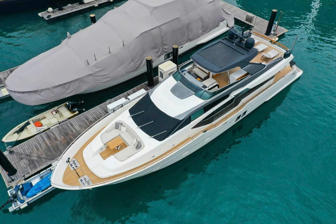 A sleek and modern yacht docked at a marina, showcasing its elegant design and spacious deck areas. aboard SANLORENZO SL86 Yacht for Sale