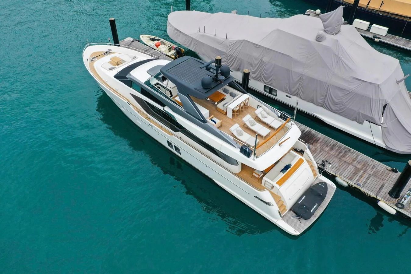 A sleek and modern yacht with a spacious flybridge docked at a marina. aboard SANLORENZO SL86 Yacht for Sale