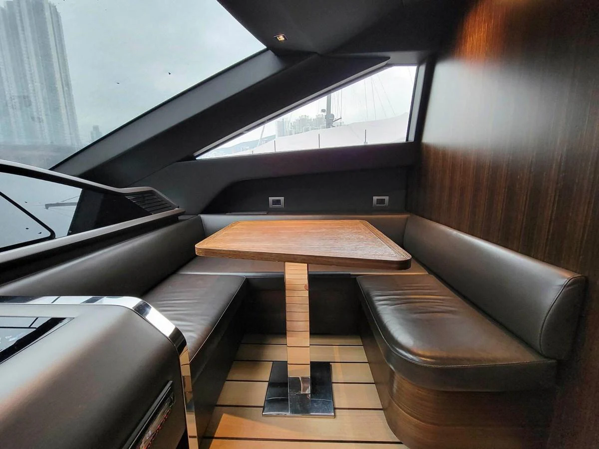 The yacht's interior dining area features a sleek and modern design with a wooden table and leather seating. aboard SANLORENZO SL86 Yacht for Sale