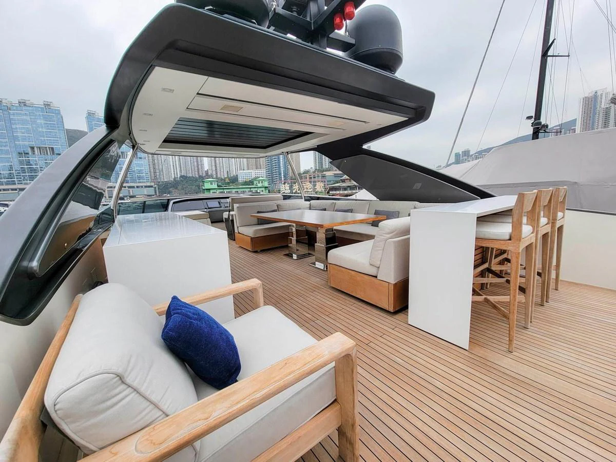 The flybridge offers a spacious and stylish outdoor seating area with modern furnishings and a cityscape view. aboard SANLORENZO SL86 Yacht for Sale