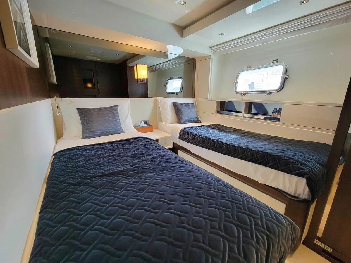 The twin stateroom features two comfortable single beds with elegant bedding and a large window for natural light. aboard SANLORENZO SL86 Yacht for Sale