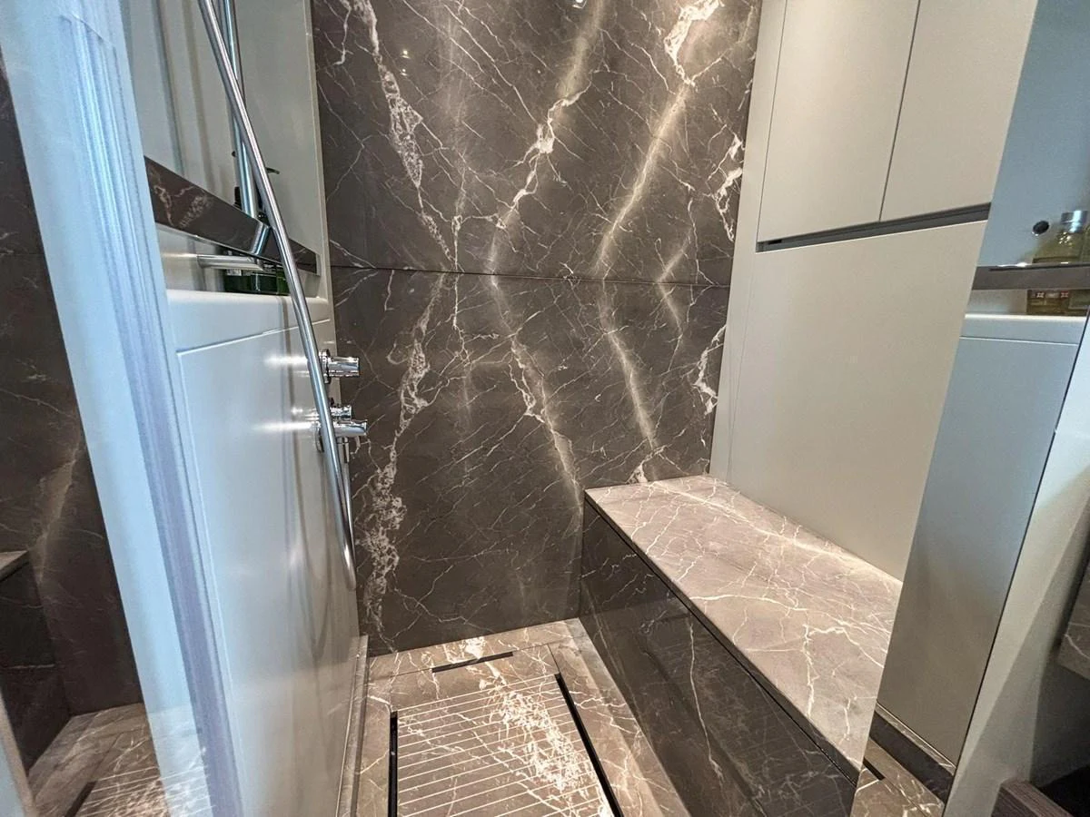 The yacht's interior features a luxurious bathroom with elegant marble finishes. aboard SANLORENZO SX88 Yacht for Sale