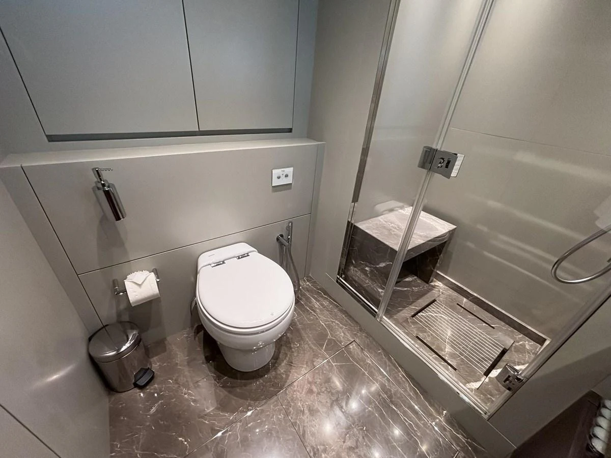 A sleek and modern yacht bathroom with a glass-enclosed shower and elegant fixtures. aboard SANLORENZO SX88 Yacht for Sale
