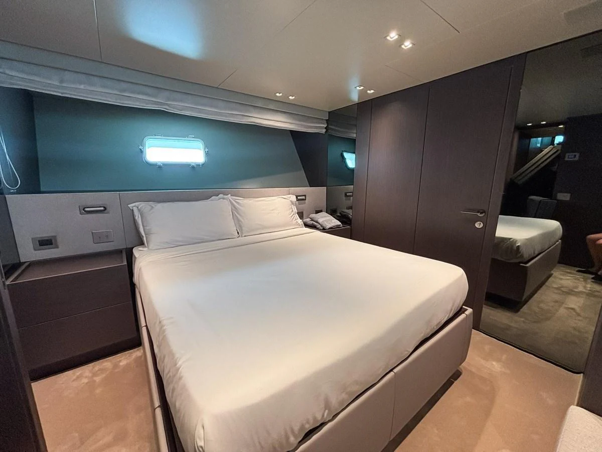 The stateroom features a luxurious bed with modern furnishings and ambient lighting. aboard SANLORENZO SX88 Yacht for Sale