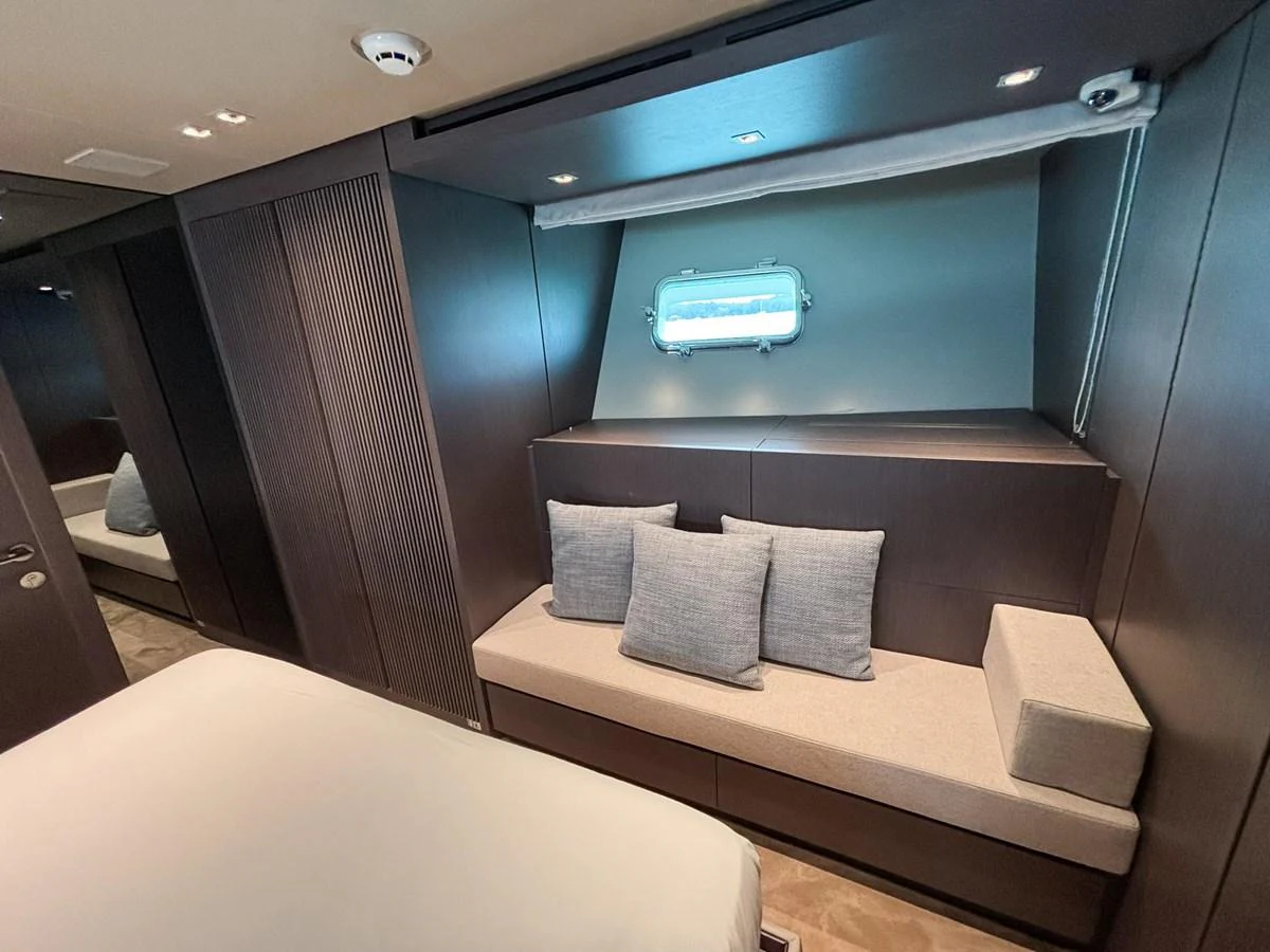 This cozy stateroom features a comfortable seating area with plush cushions and a small window for natural light. aboard SANLORENZO SX88 Yacht for Sale