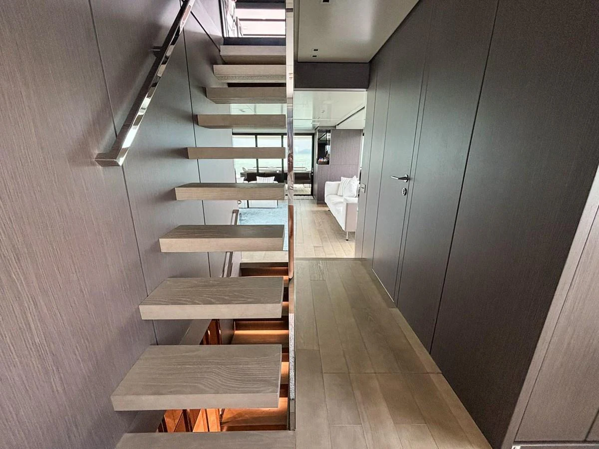 A modern interior staircase with sleek wooden steps and metal railings. aboard SANLORENZO SX88 Yacht for Sale