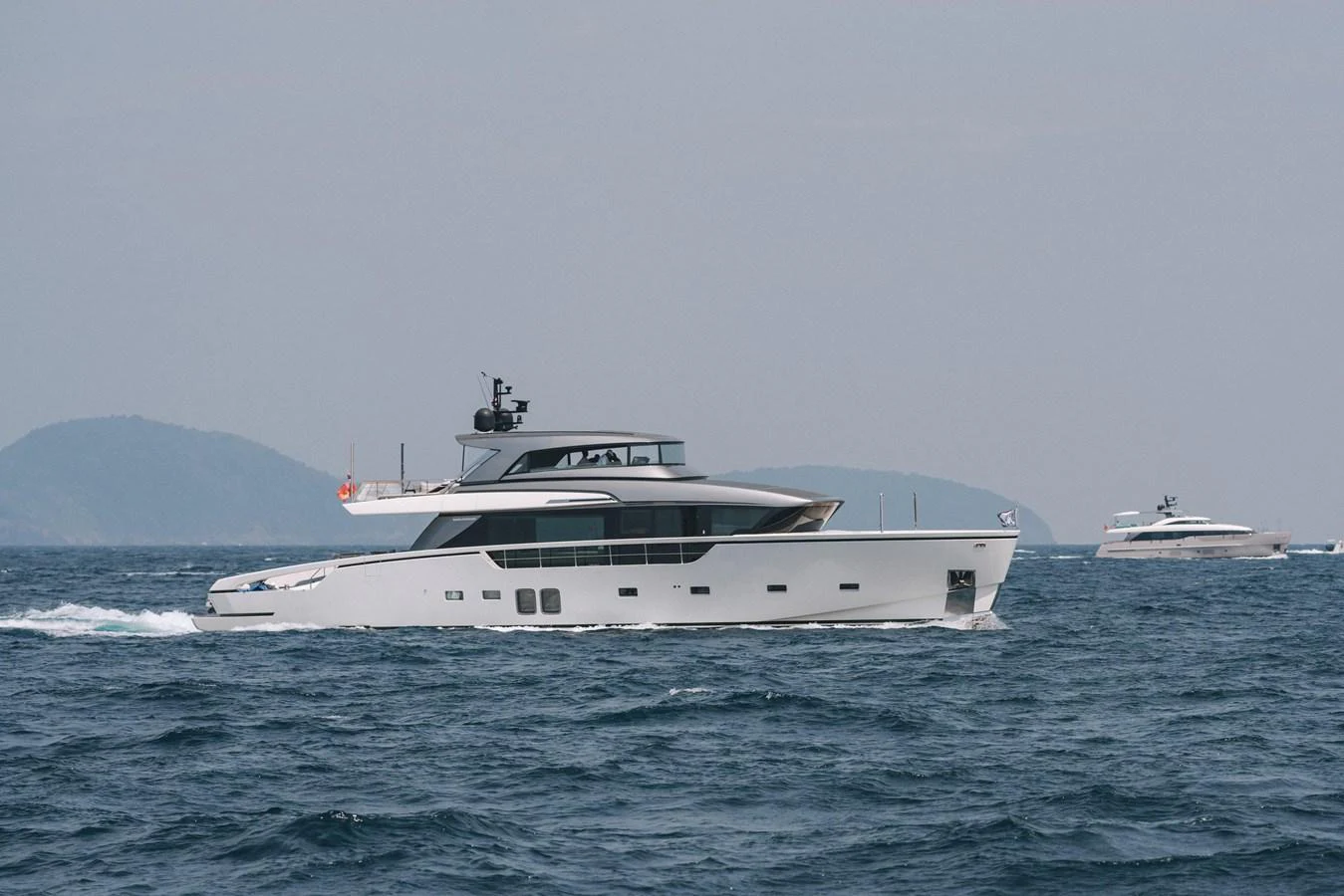 A sleek and modern yacht cruises through the open sea, showcasing its elegant design and spacious layout. aboard SANLORENZO SX88 Yacht for Sale
