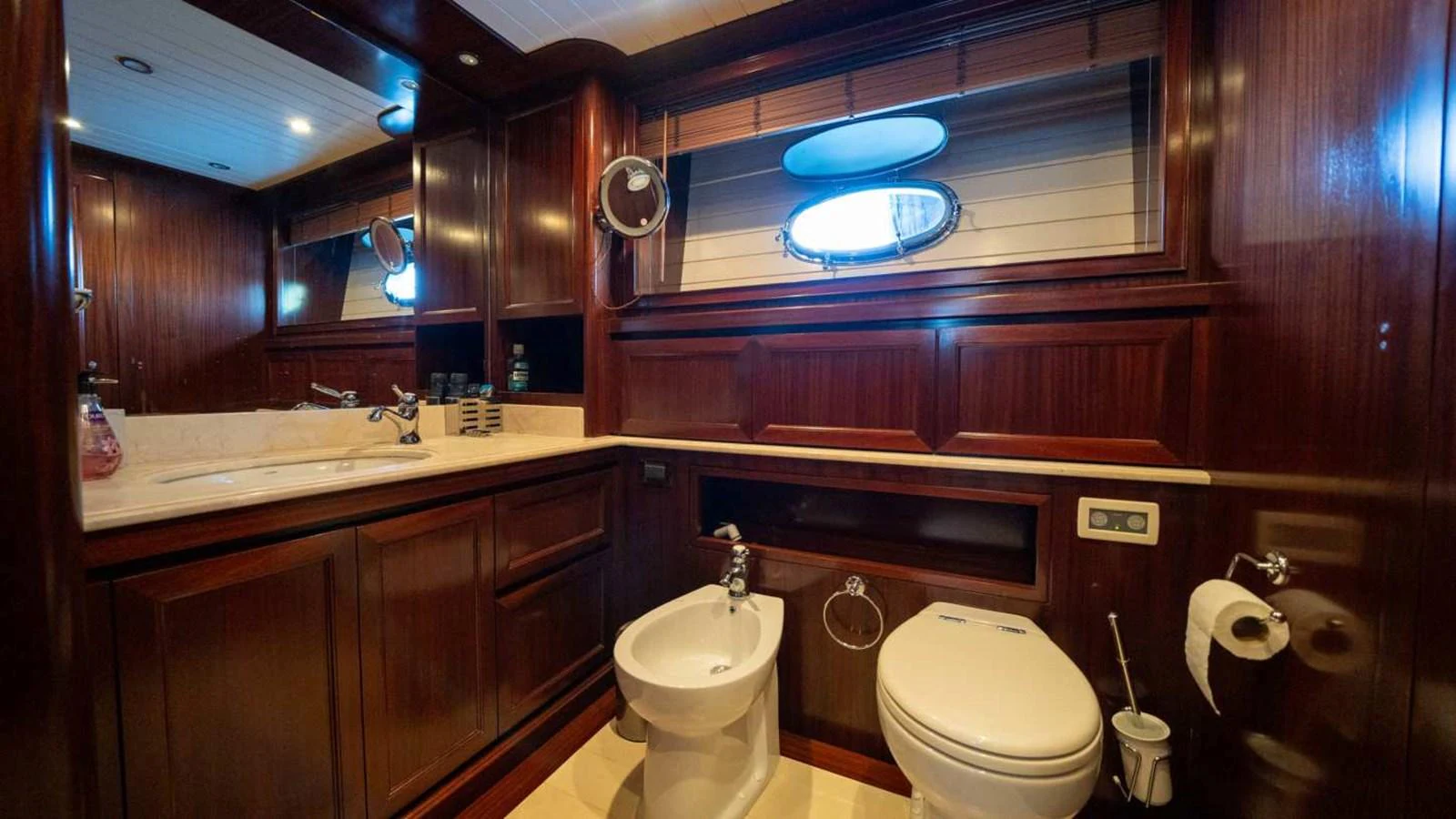 The yacht's bathroom features rich wood paneling and modern fixtures, creating a luxurious and comfortable space. aboard SILVER Yacht for Sale