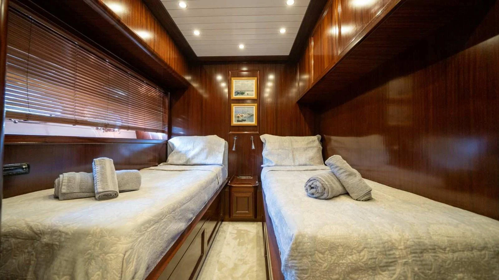 A cozy twin stateroom with elegant wooden paneling and soft lighting. aboard SILVER Yacht for Sale