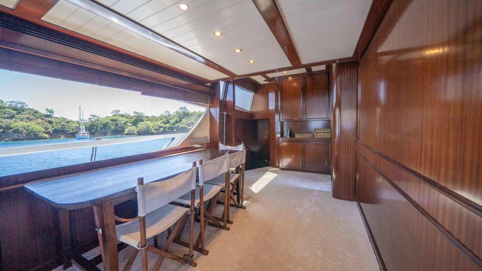 The yacht's dining area features elegant wood paneling and large windows offering scenic views. aboard SILVER Yacht for Sale