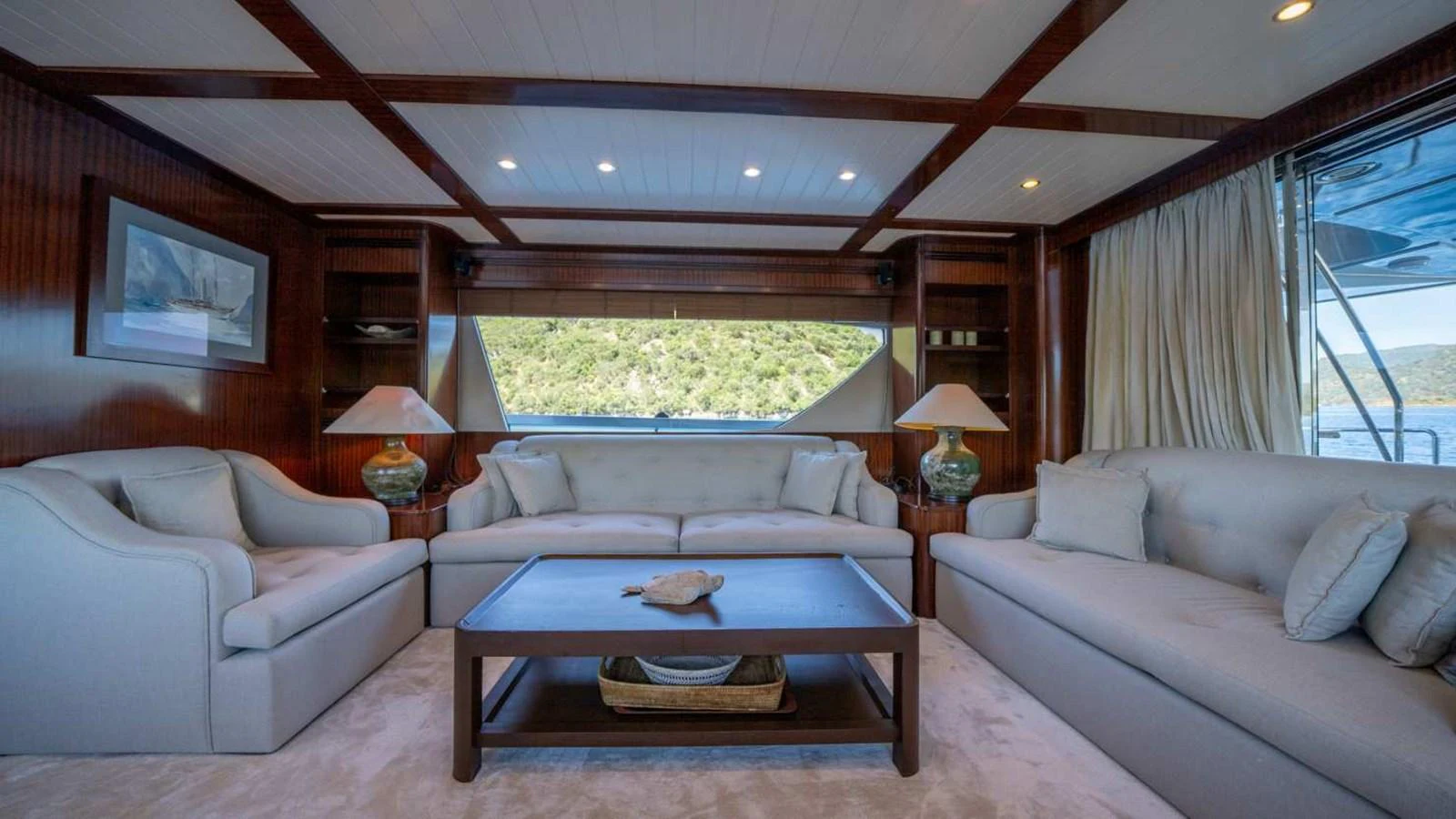 The salon features comfortable seating and elegant decor with large windows offering scenic views. aboard SILVER Yacht for Sale