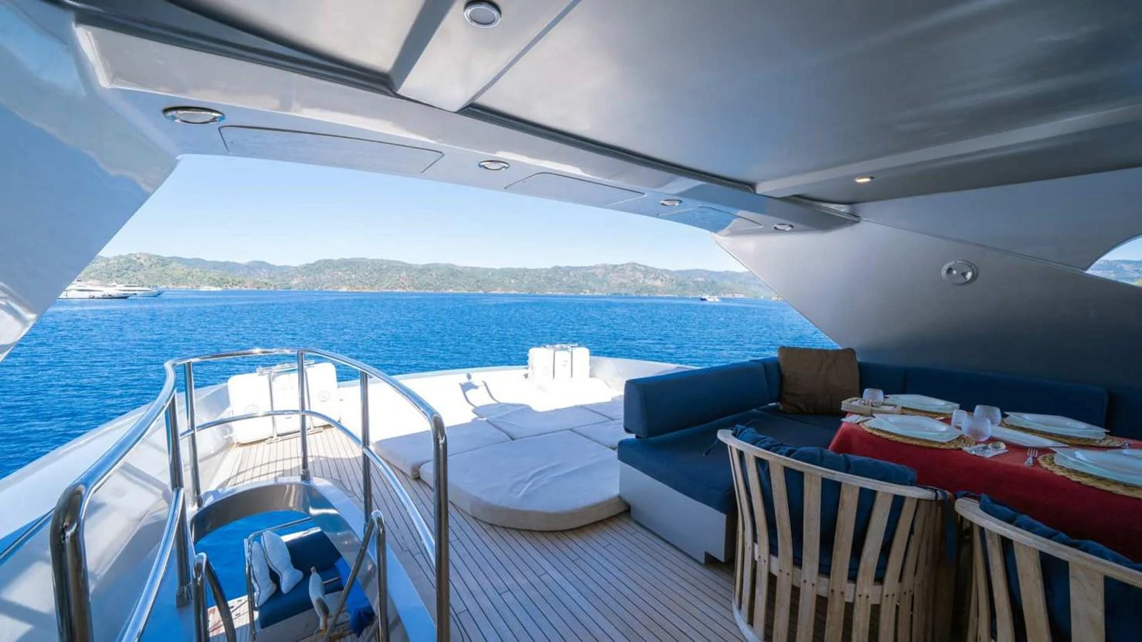 The aft deck features a comfortable seating area with a dining table and sun loungers, offering stunning views of the surrounding waters. aboard SILVER Yacht for Sale