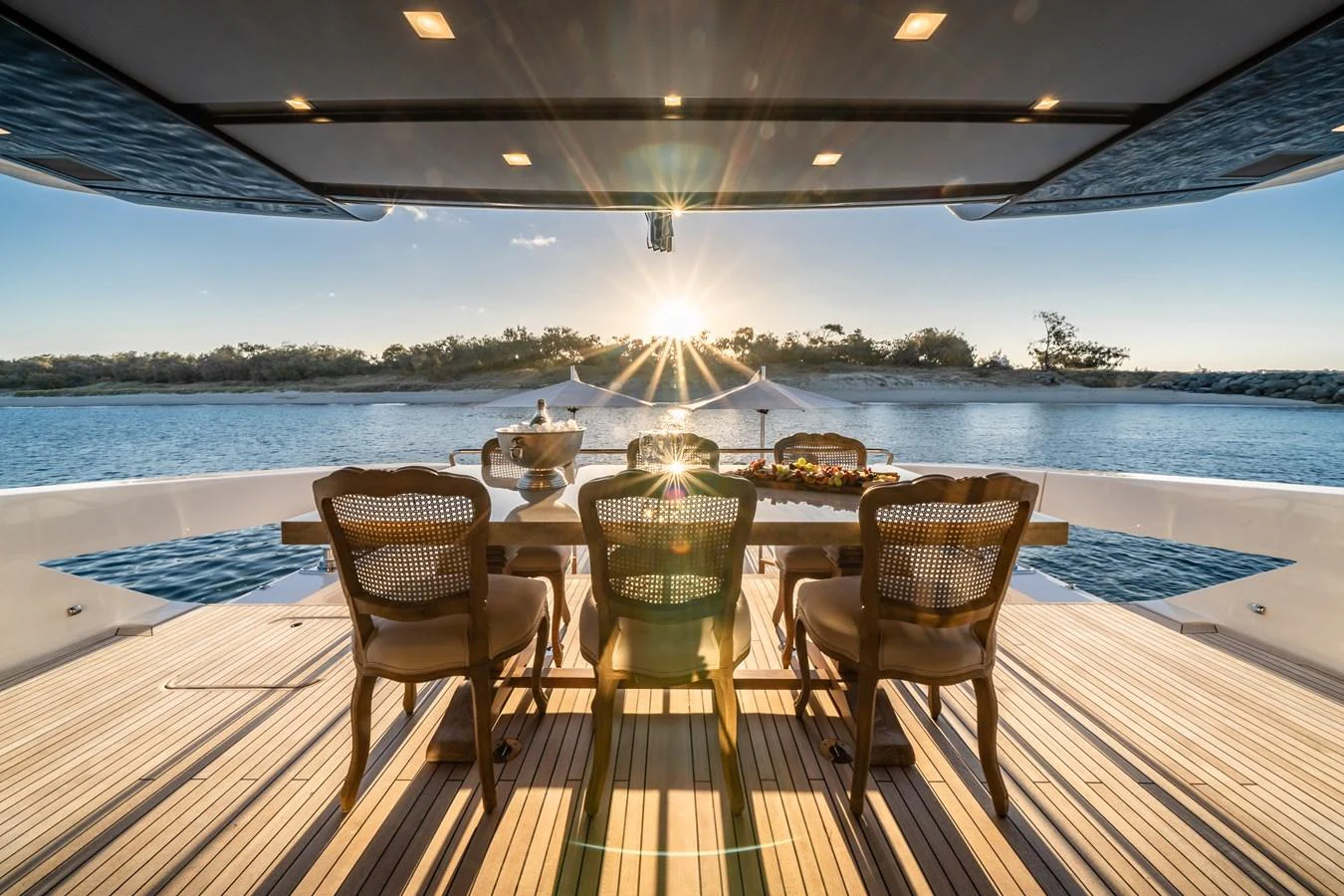 The aft deck features an elegant outdoor dining area with stunning sunset views over the water. aboard VIOLETTA Yacht for Sale