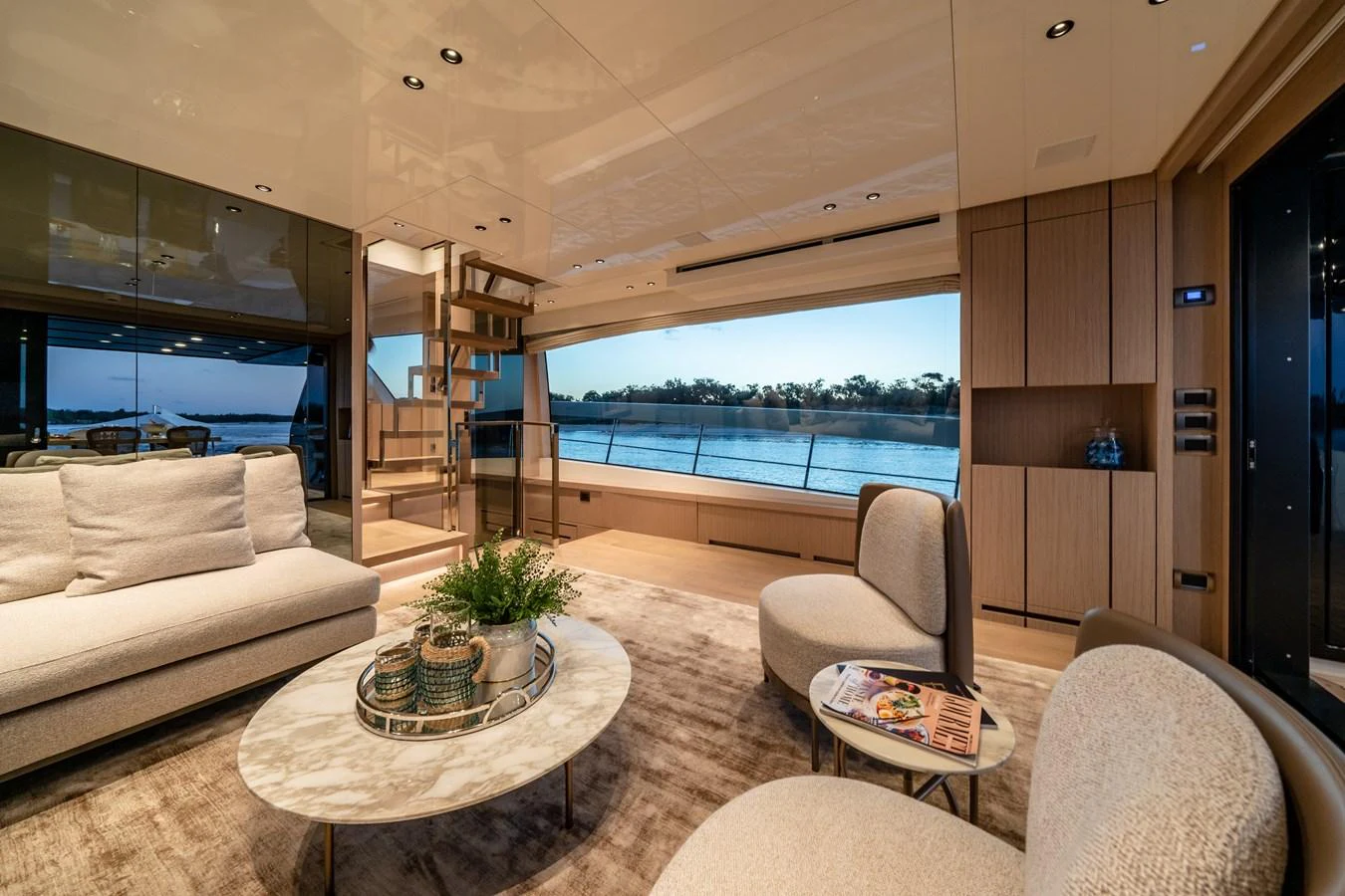 The salon features elegant furnishings with a stunning view of the water through large windows. aboard VIOLETTA Yacht for Sale