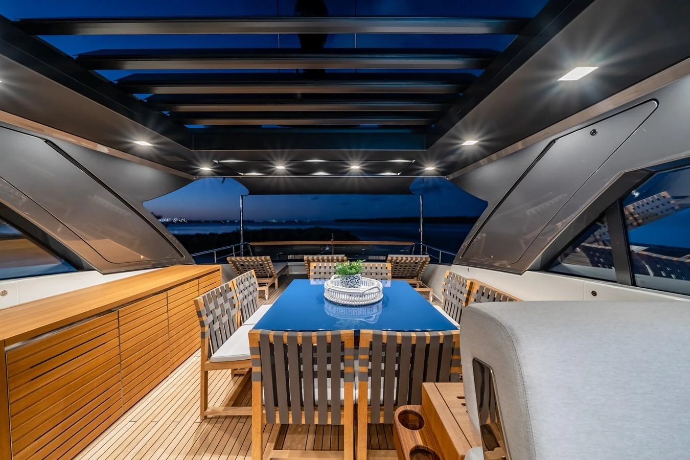 A stylish dining area on a yacht, featuring a sleek table and comfortable seating under a modern canopy. aboard VIOLETTA Yacht for Sale