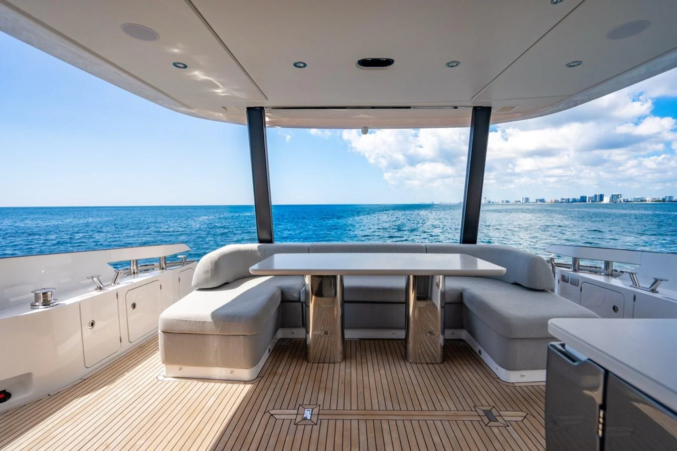 The aft deck offers a spacious and inviting area with comfortable seating and a large table, perfect for enjoying the ocean views. aboard EFFORTLESS Yacht for Sale
