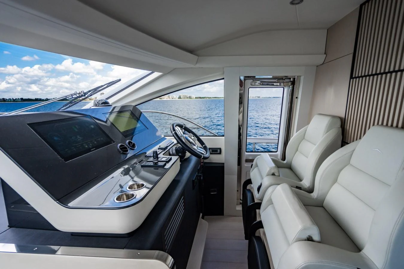 The helm station features modern controls and luxurious seating with a panoramic view of the water. aboard EFFORTLESS Yacht for Sale