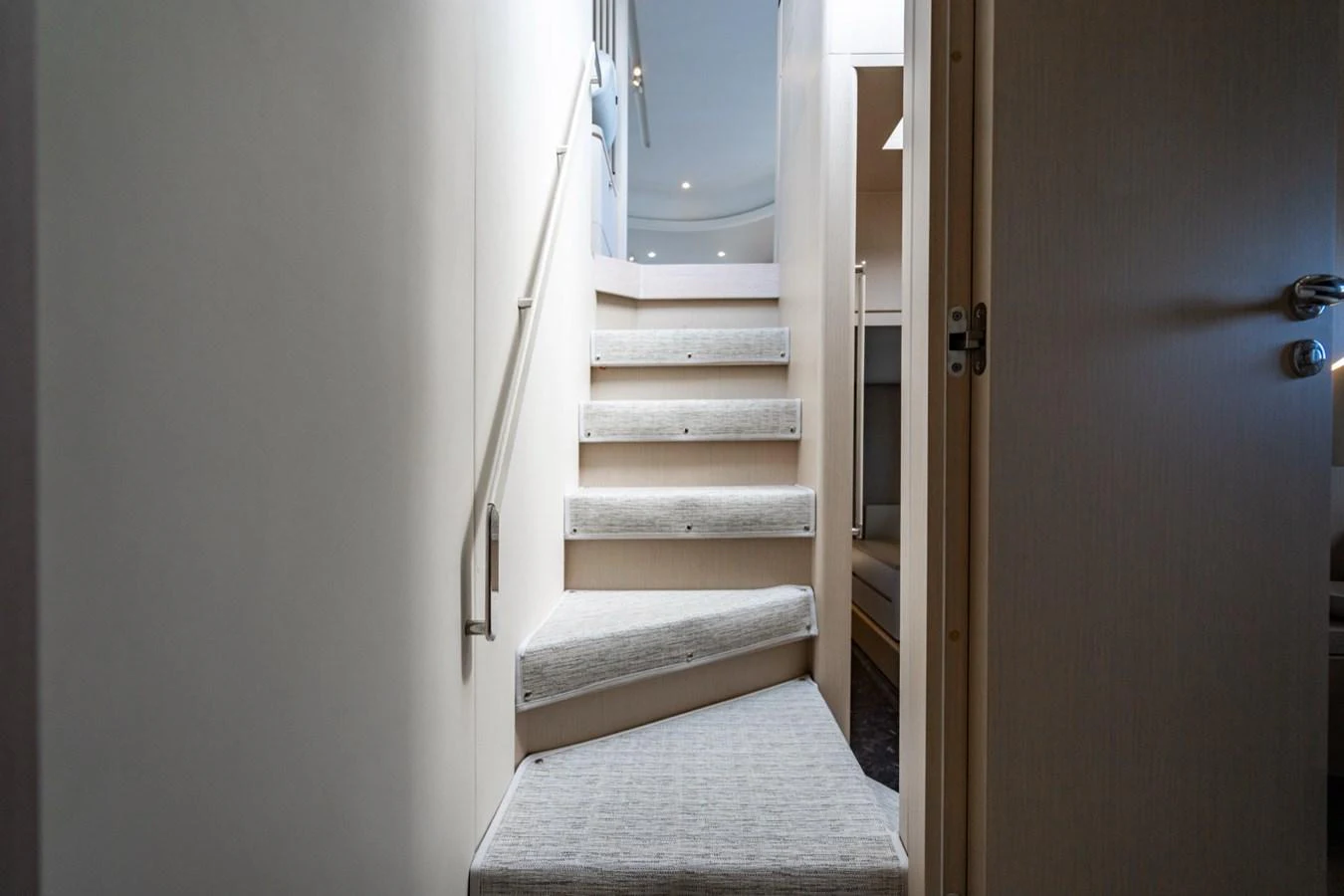 A well-lit staircase with modern design leads to the upper deck of the yacht. aboard EFFORTLESS Yacht for Sale