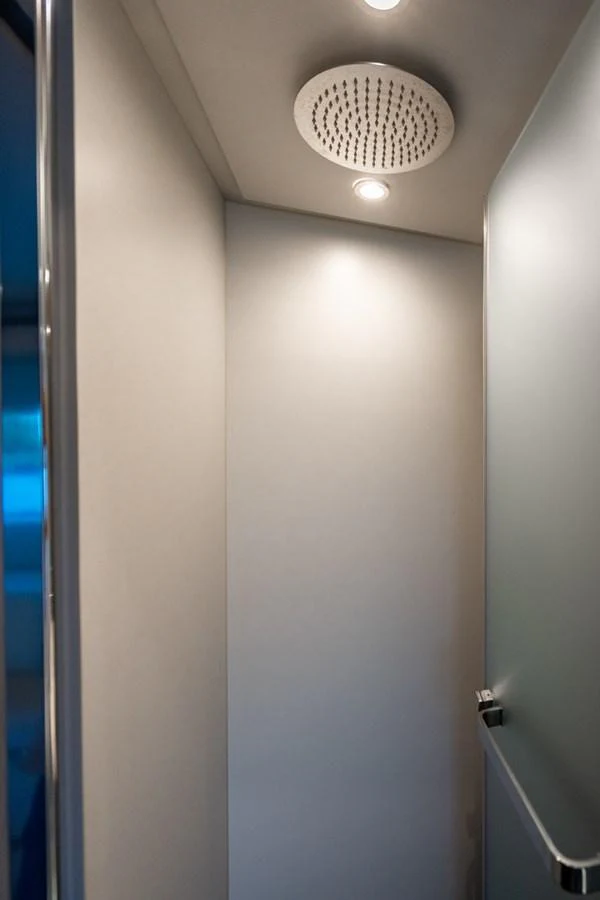 A modern shower area with sleek fixtures and ambient lighting. aboard EFFORTLESS Yacht for Sale