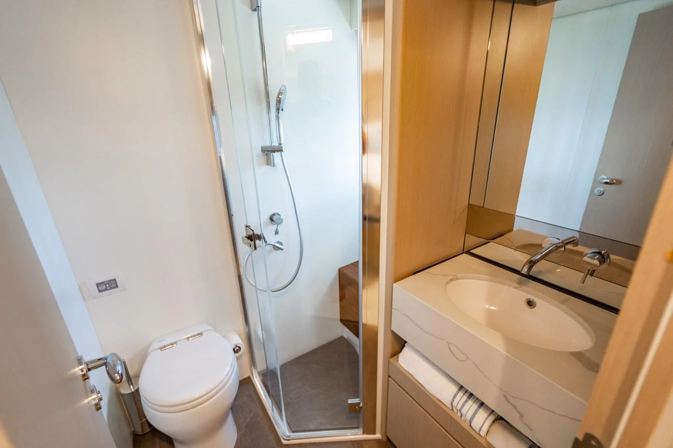 The yacht's bathroom features a modern shower, toilet, and sleek sink area with ample storage. aboard EFFORTLESS Yacht for Sale