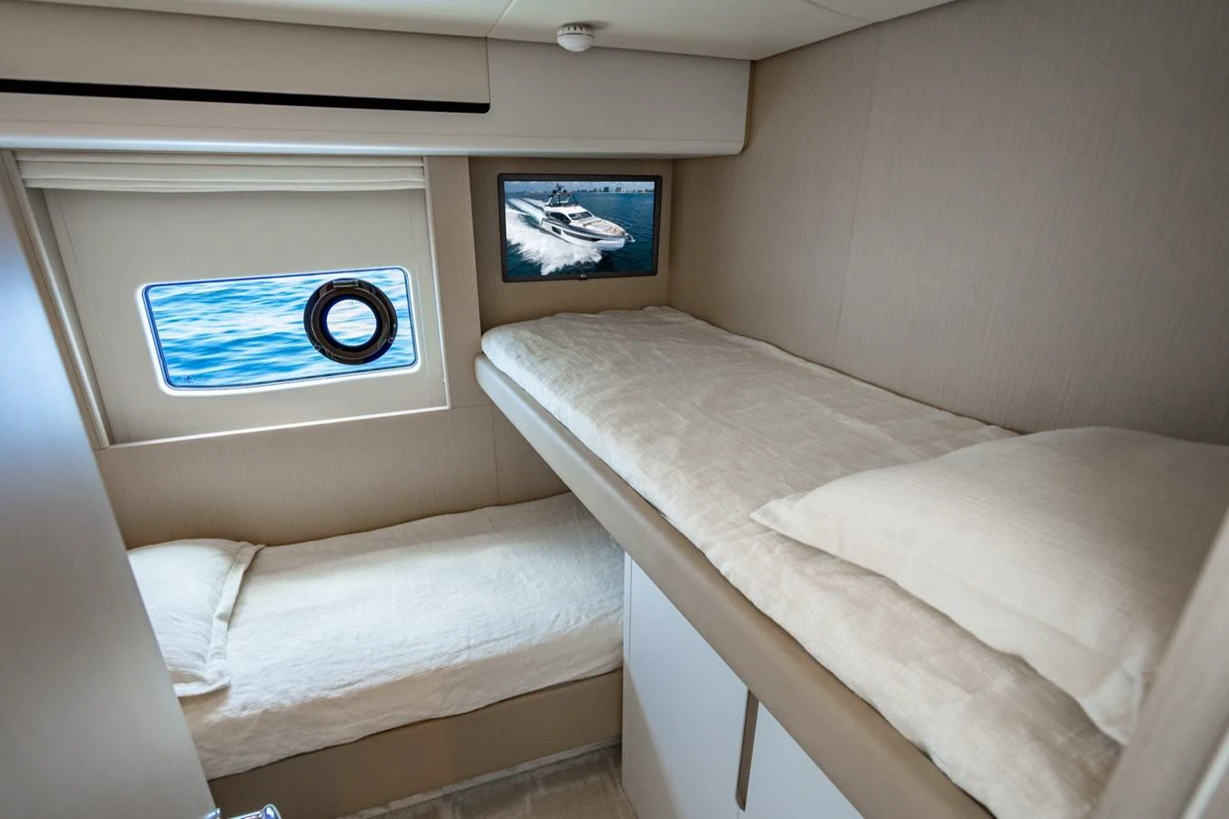 A cozy guest cabin with twin bunk beds and a window offering a view of the sea. aboard EFFORTLESS Yacht for Sale