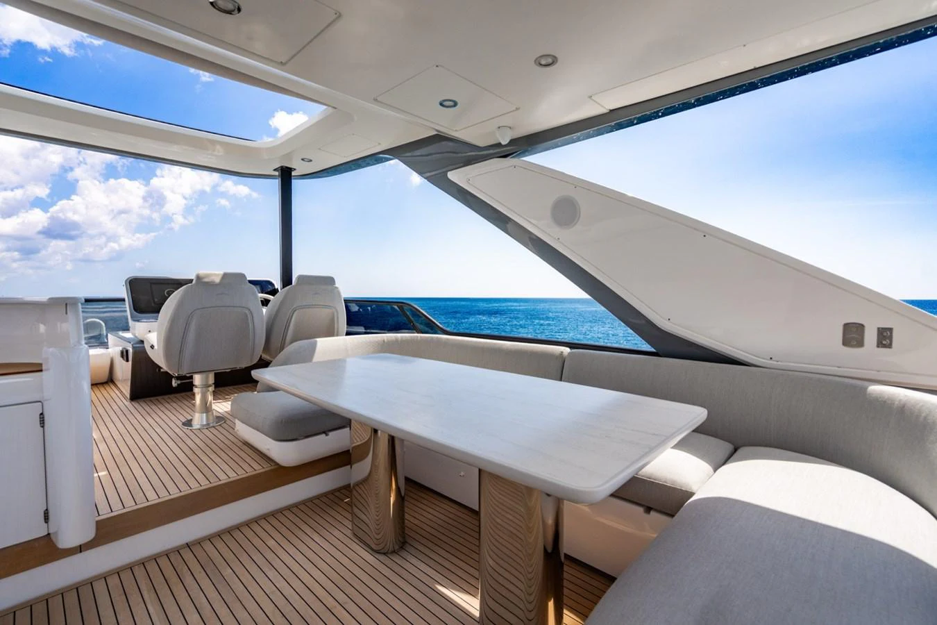 The aft deck features a spacious seating area with a large table, perfect for alfresco dining with a stunning ocean view. aboard EFFORTLESS Yacht for Sale