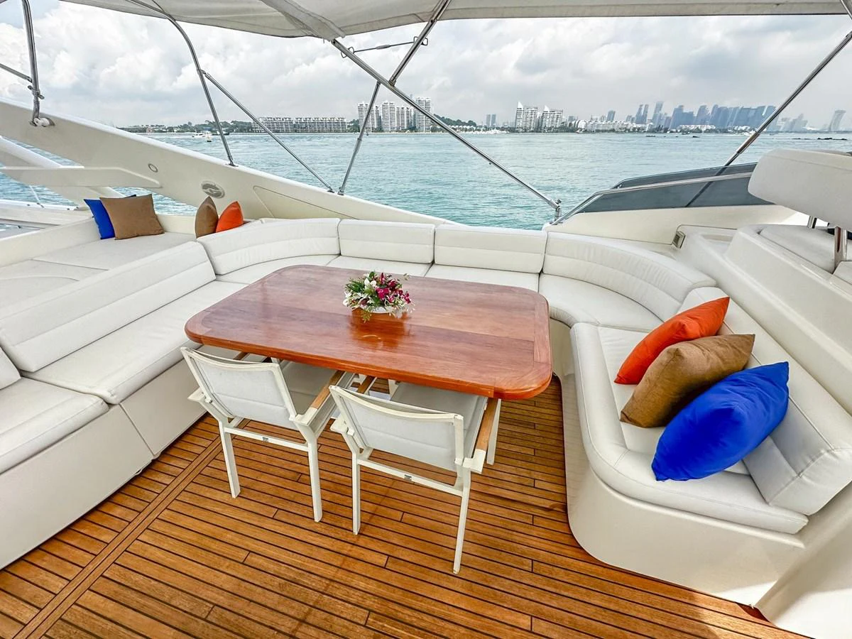 The aft deck features a spacious seating area with a wooden table and plush cushions, perfect for outdoor dining and relaxation. aboard CUSTOM LINE 112 Yacht for Sale