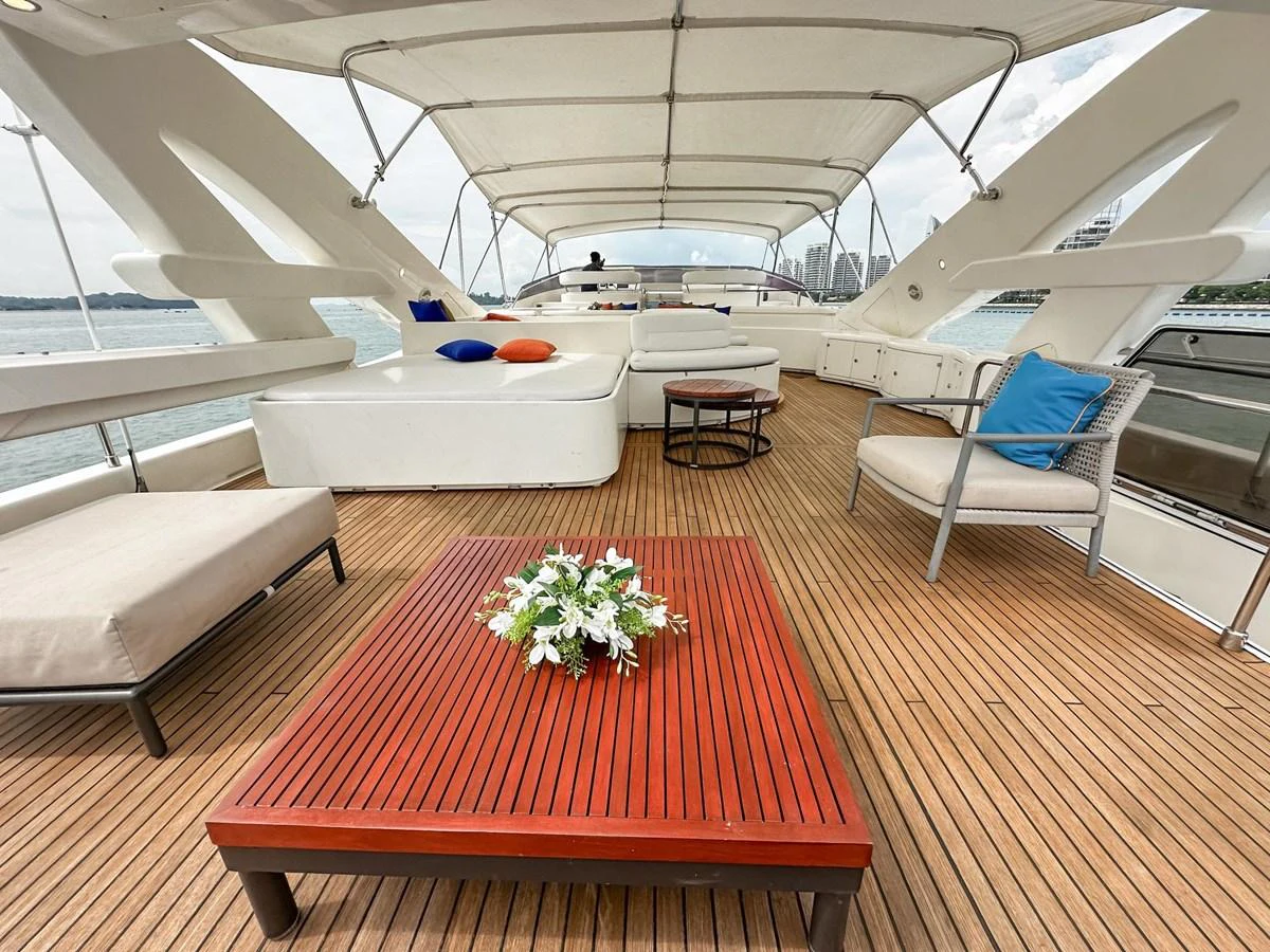The flybridge features ample seating and lounging areas with a stylish wooden deck and a canopy for shade. aboard CUSTOM LINE 112 Yacht for Sale