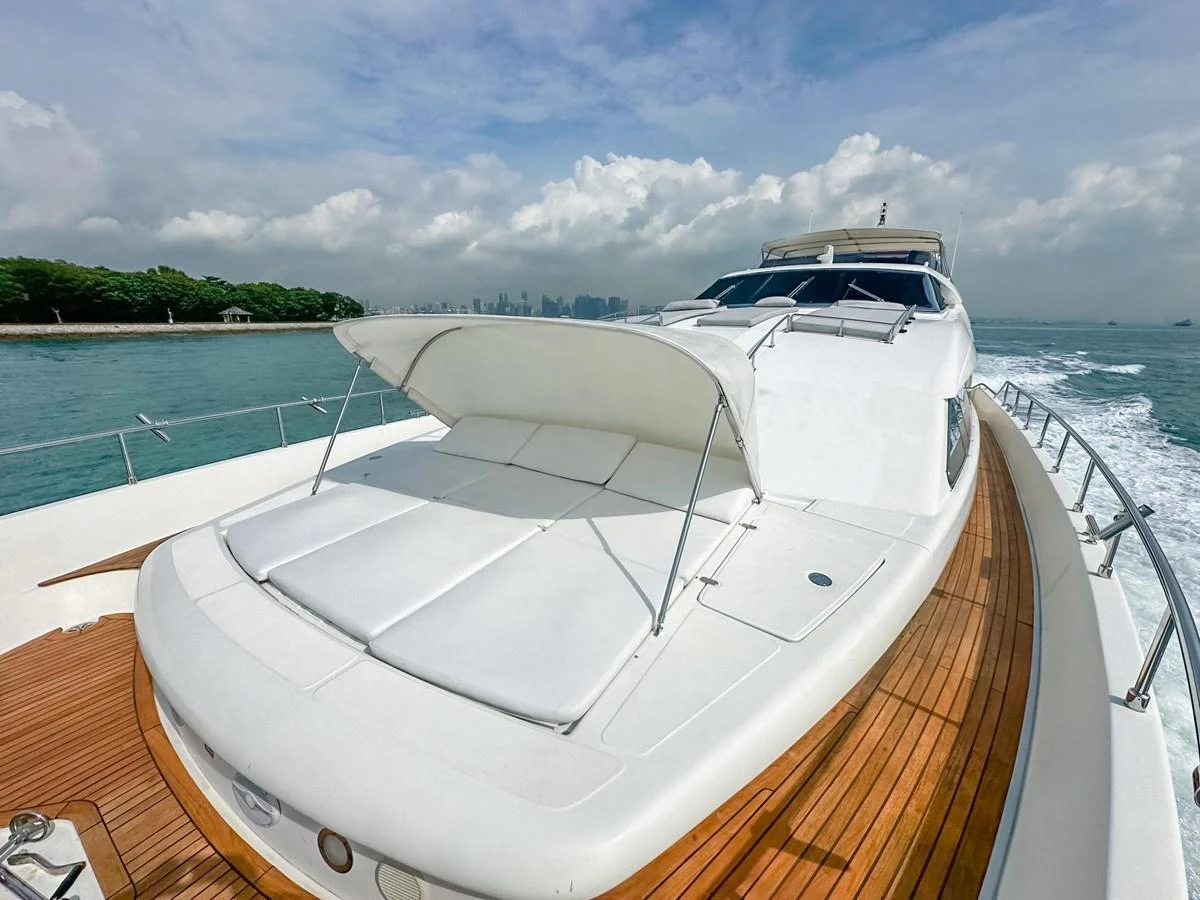 The yacht's foredeck features a spacious sunbathing area with plush white cushions and a sleek design. aboard CUSTOM LINE 112 Yacht for Sale
