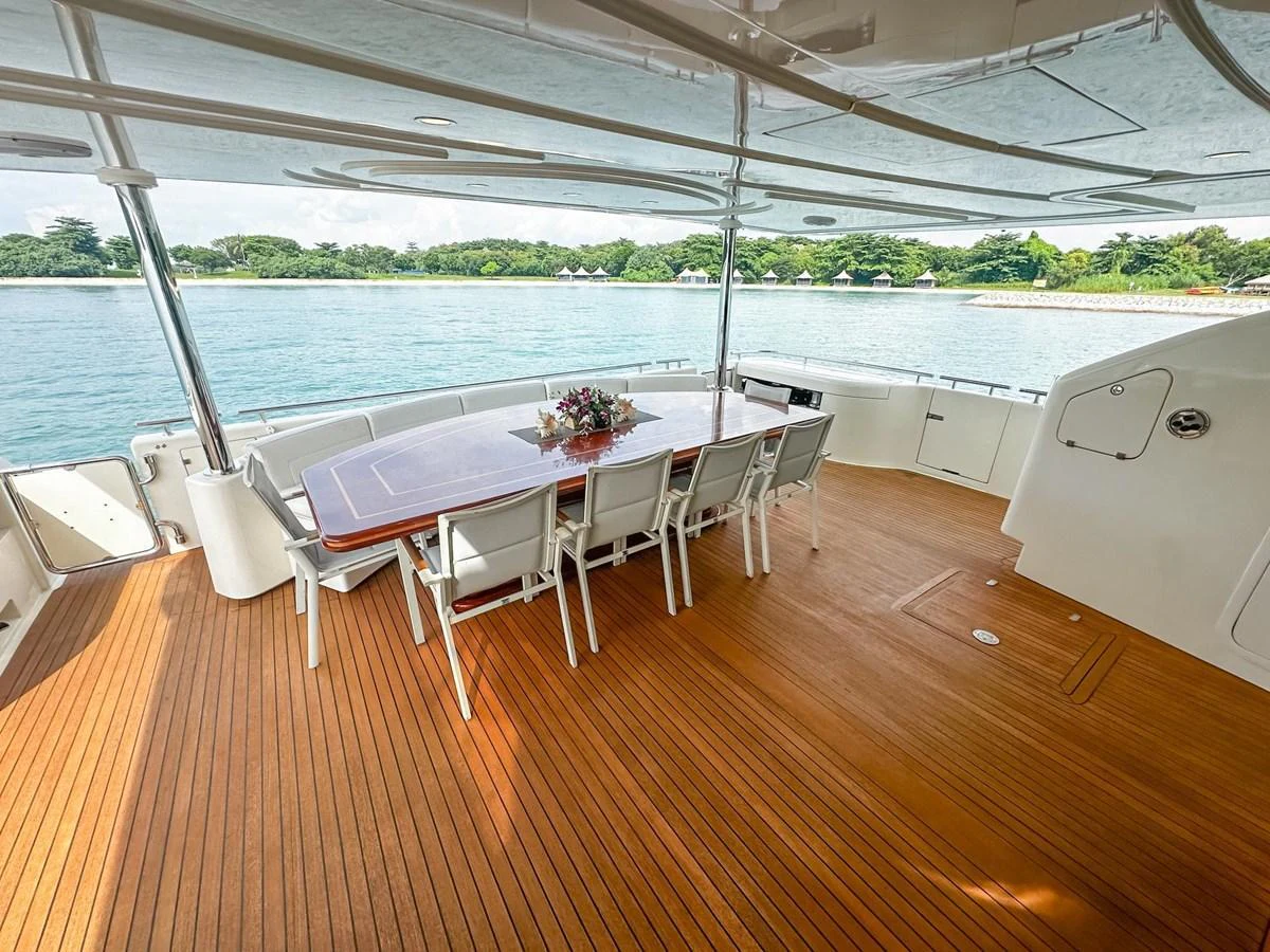 The aft deck features a spacious dining area with a large table and comfortable seating, perfect for alfresco meals with a view. aboard CUSTOM LINE 112 Yacht for Sale