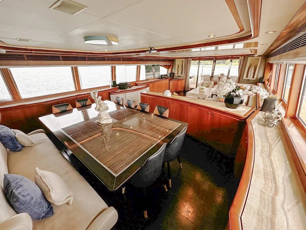 The yacht's dining area features a luxurious table with ample seating and panoramic windows offering stunning views. aboard CUSTOM LINE 112 Yacht for Sale
