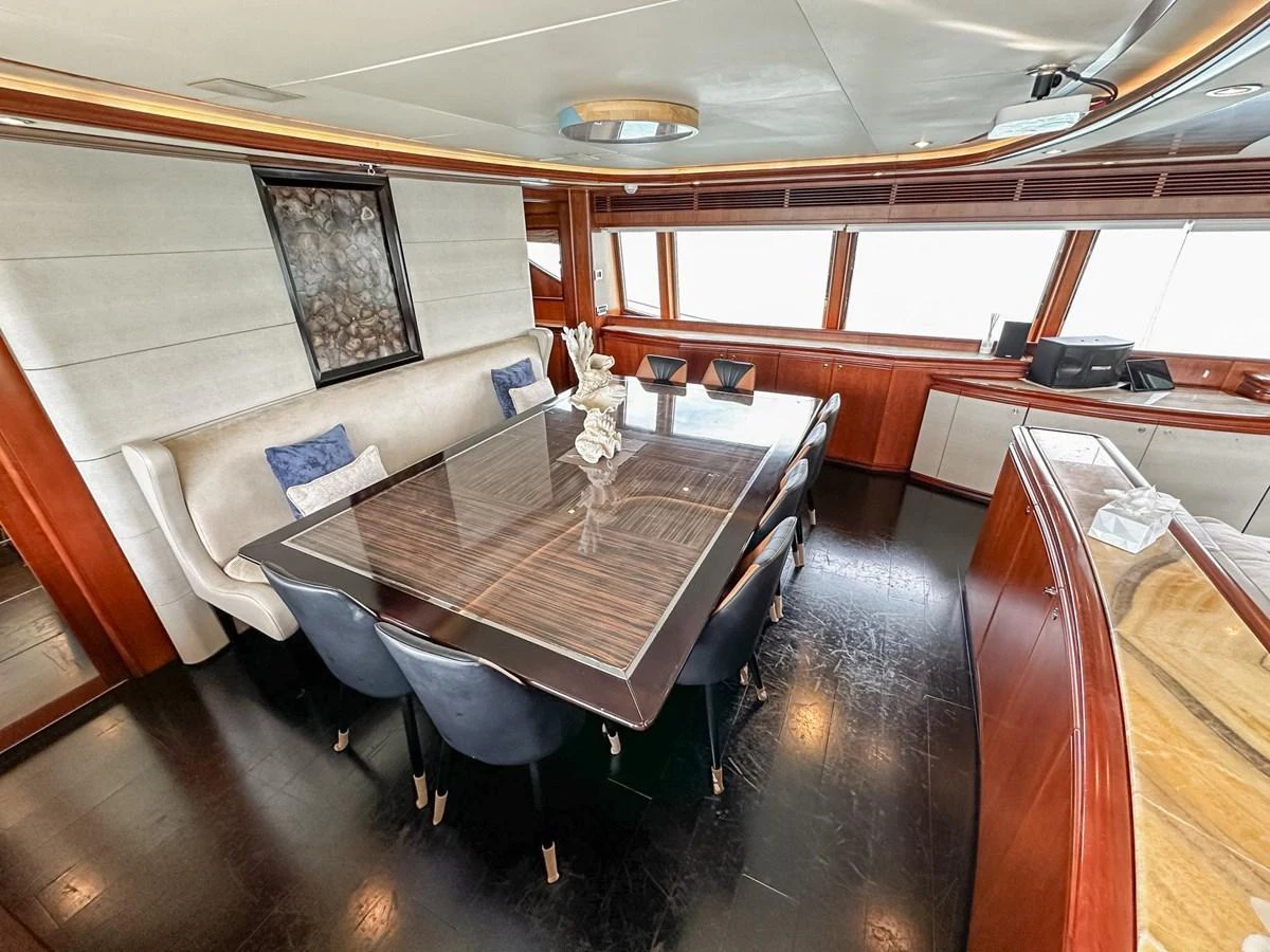 The yacht's dining area features a sleek table with comfortable seating and elegant decor. aboard CUSTOM LINE 112 Yacht for Sale