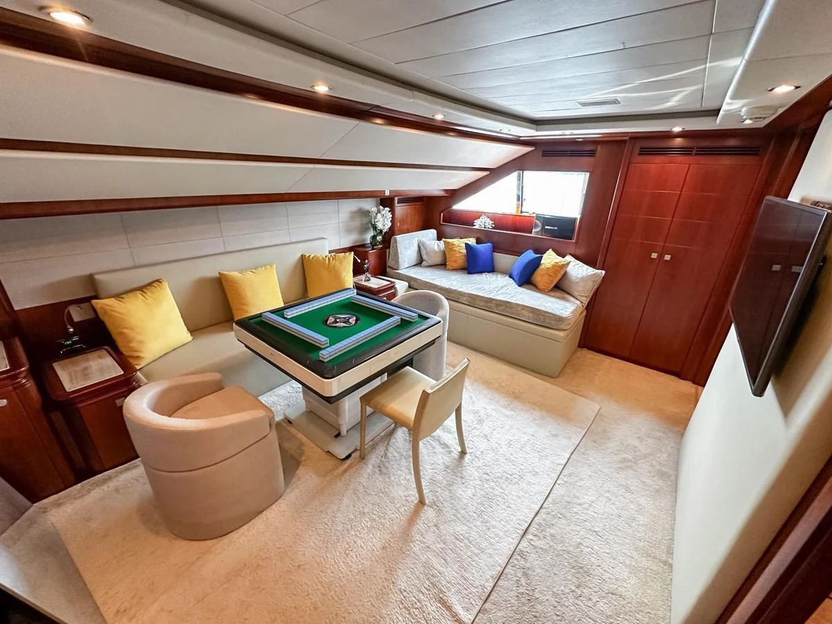 A cozy lounge area featuring a card table and comfortable seating with vibrant cushions. aboard CUSTOM LINE 112 Yacht for Sale