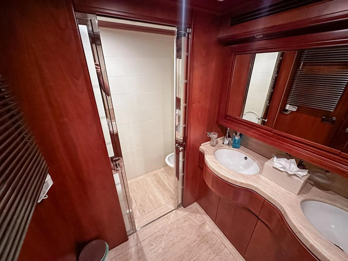 The yacht's bathroom features elegant wood finishes and modern fixtures. aboard CUSTOM LINE 112 Yacht for Sale
