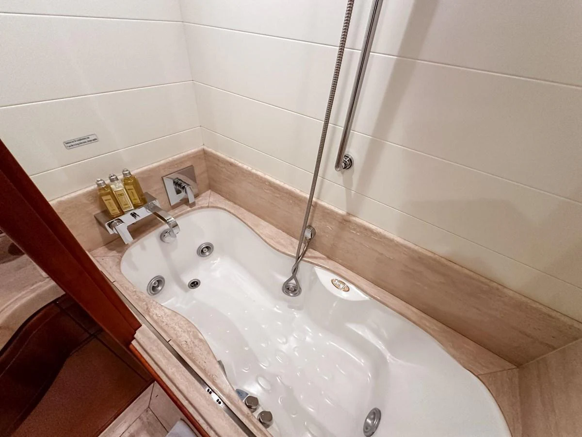 The yacht's bathroom features a luxurious bathtub with modern fixtures. aboard CUSTOM LINE 112 Yacht for Sale