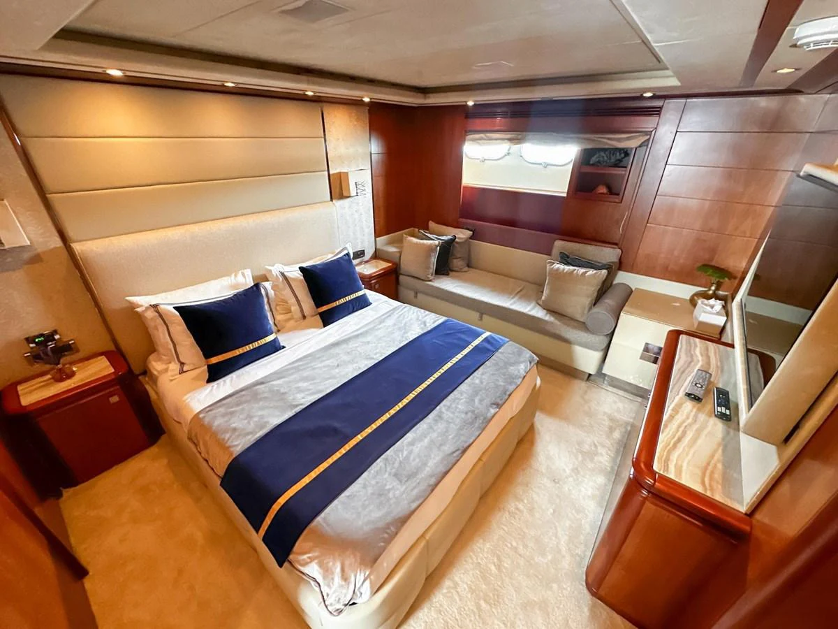 The master stateroom features a luxurious bed, elegant wood paneling, and a comfortable seating area. aboard CUSTOM LINE 112 Yacht for Sale
