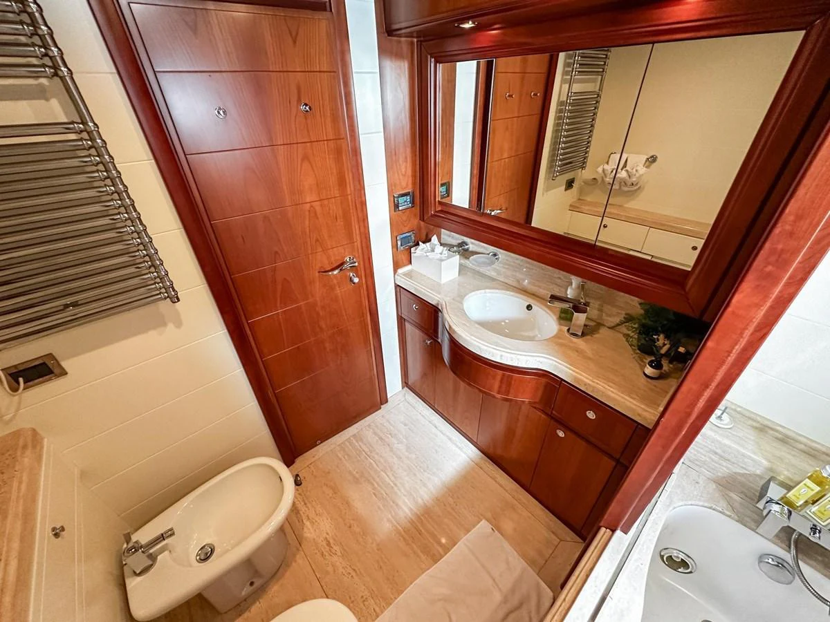The yacht's bathroom features elegant wood finishes and modern fixtures. aboard CUSTOM LINE 112 Yacht for Sale