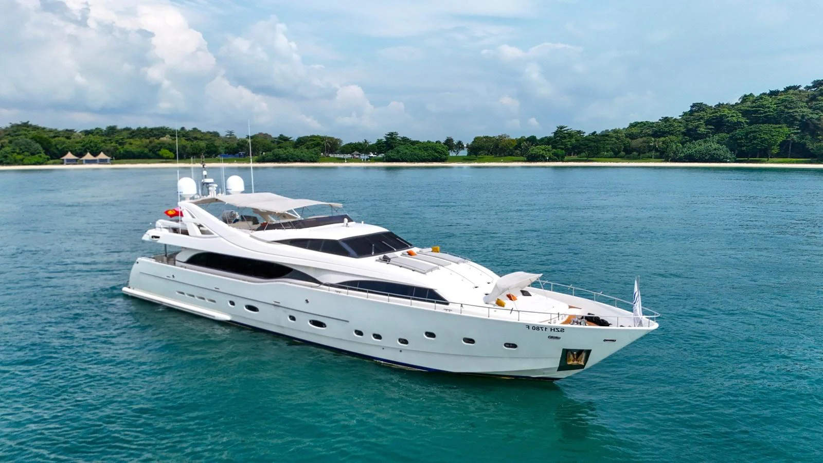 A sleek and elegant yacht cruising on calm blue waters with a scenic shoreline in the background. aboard CUSTOM LINE 112 Yacht for Sale
