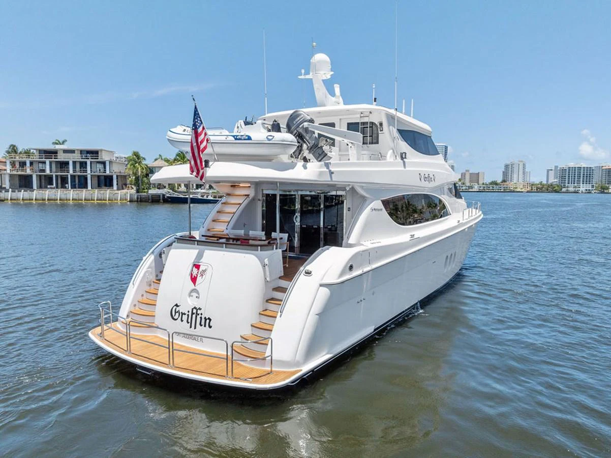 A luxurious yacht is anchored on calm waters, showcasing its elegant aft deck and sleek design. aboard GRIFFIN Yacht for Sale